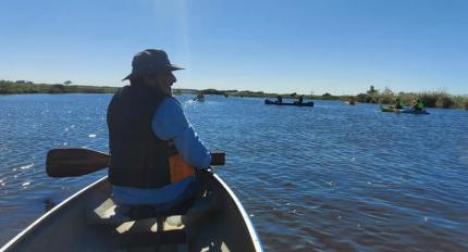Hombre navegando por el Arroyo solís Chico en una canoa a remo.