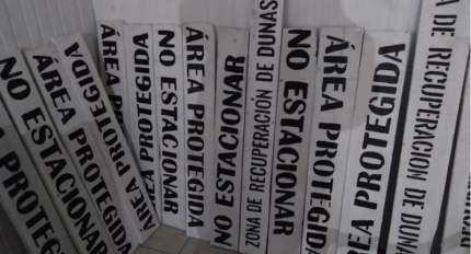 Carteles realizados por funcionarios municipales y jornales solidarios, con las leyendas: No estacionar, Área protegida y zona de recuperación de dunas.