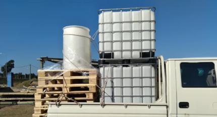 Tanques de plástico donados por CESEA y pallets cargados en el camión del Municipio, prontos para ser transportados.